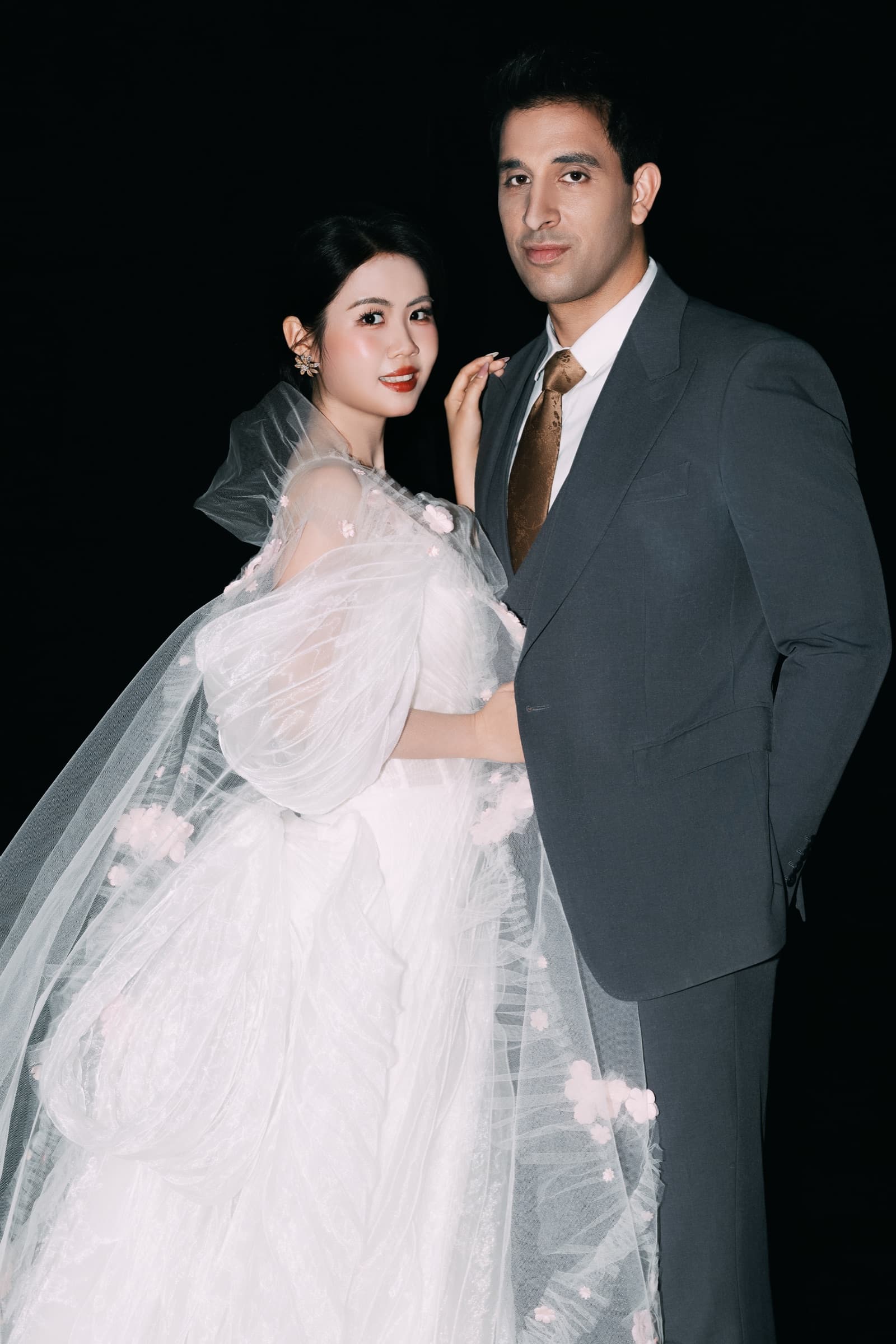 The couple close together, wrapped in soft tulle